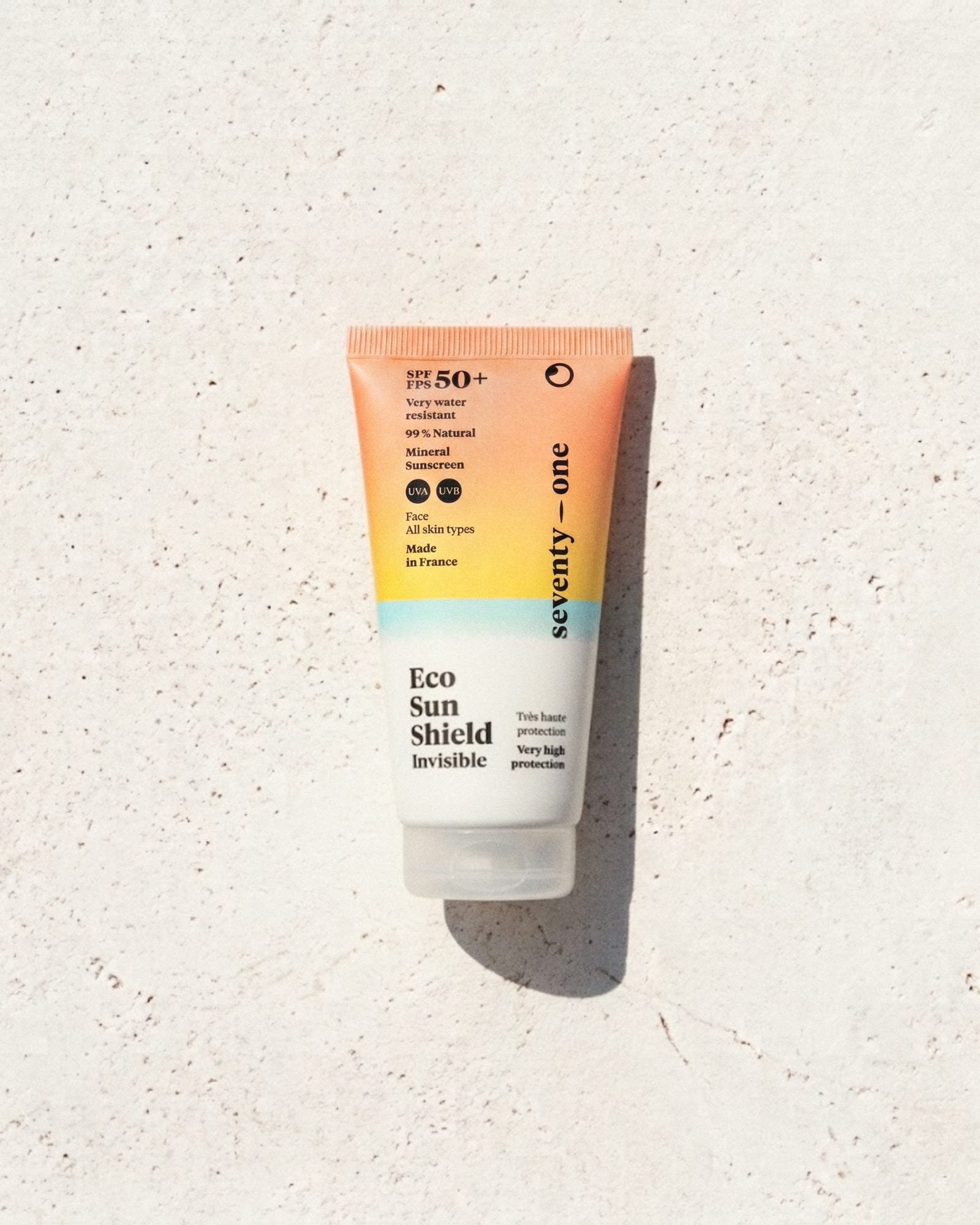 EcoSun Shield SPF 50+ SeventyOne Percent, crème solaire minérale invisible visage 50 ml, tube posé sur une pierre blanche au soleil