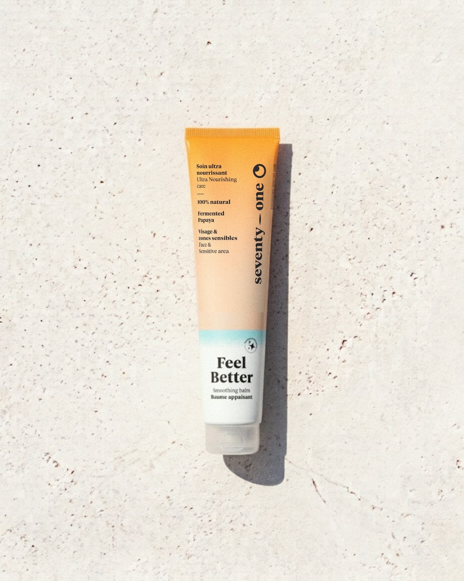 Feel Better SeventyOne Percent, baume apaisant ultra nourrissant visage et zones sensibles 40 ml, tube posé sur une pierre blanche au soleil