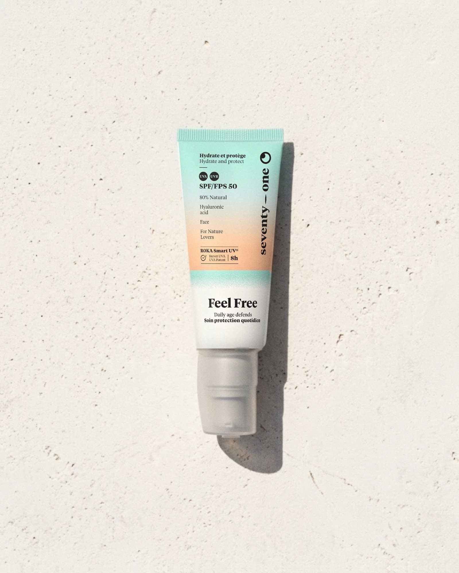 Feel Free SPF 50 SeventyOne Percent, crème de jour hydratante à l'acide hyaluronique 40 ml, tube posé sur une pierre blanche au soleil