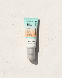 Feel Free SPF 50 SeventyOne Percent, crème de jour hydratante à l'acide hyaluronique 40 ml, tube posé sur une pierre blanche au soleil