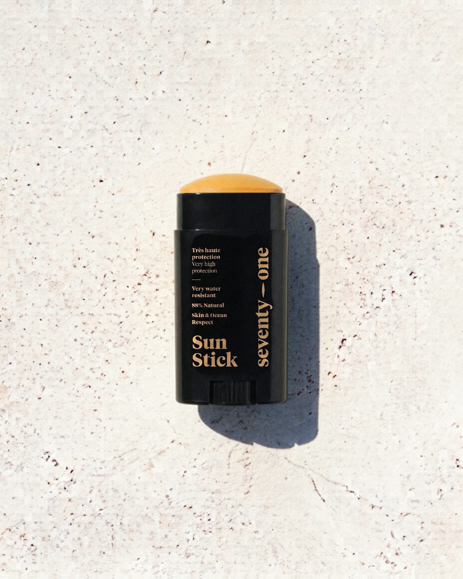 Stick solaire Pacha Mama SPF 50+ SeventyOne Percent, très haute protection résistant à l'eau 15 g, posé sur une pierre blanche au soleil
