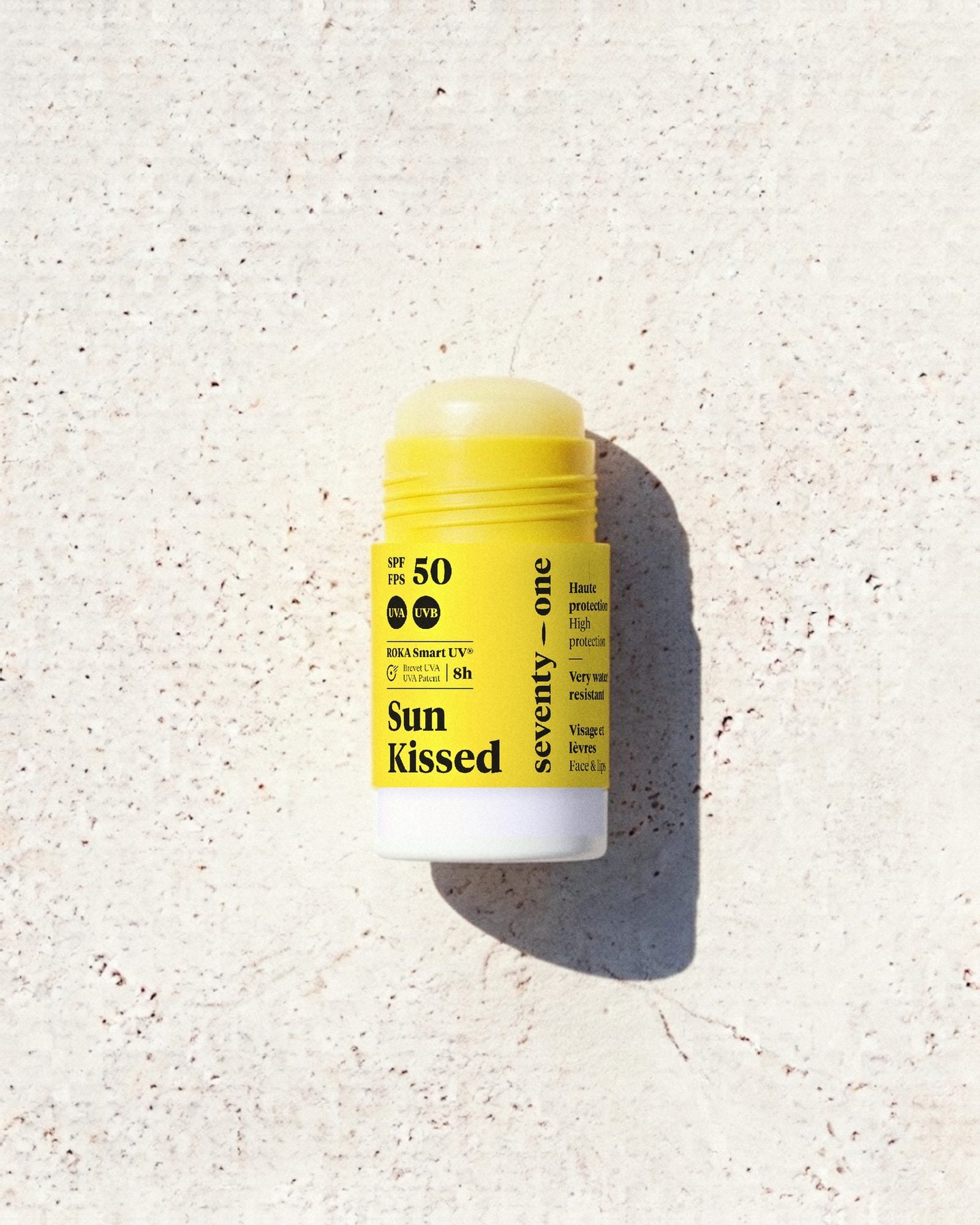 Stick solaire SunKissed SPF 50 SeventyOne Percent, haute protection visage et lèvres 15 g, posé sur une pierre blanche au soleil