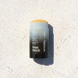 Stick solaire The Invisible SPF 50 SeventyOne Percent, haute protection très résistant à l'eau 15 g, posé sur une pierre blanche au soleil