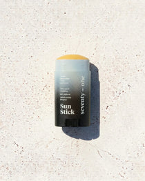 Stick solaire The Invisible SPF 50 SeventyOne Percent, haute protection très résistant à l'eau 15 g, posé sur une pierre blanche au soleil