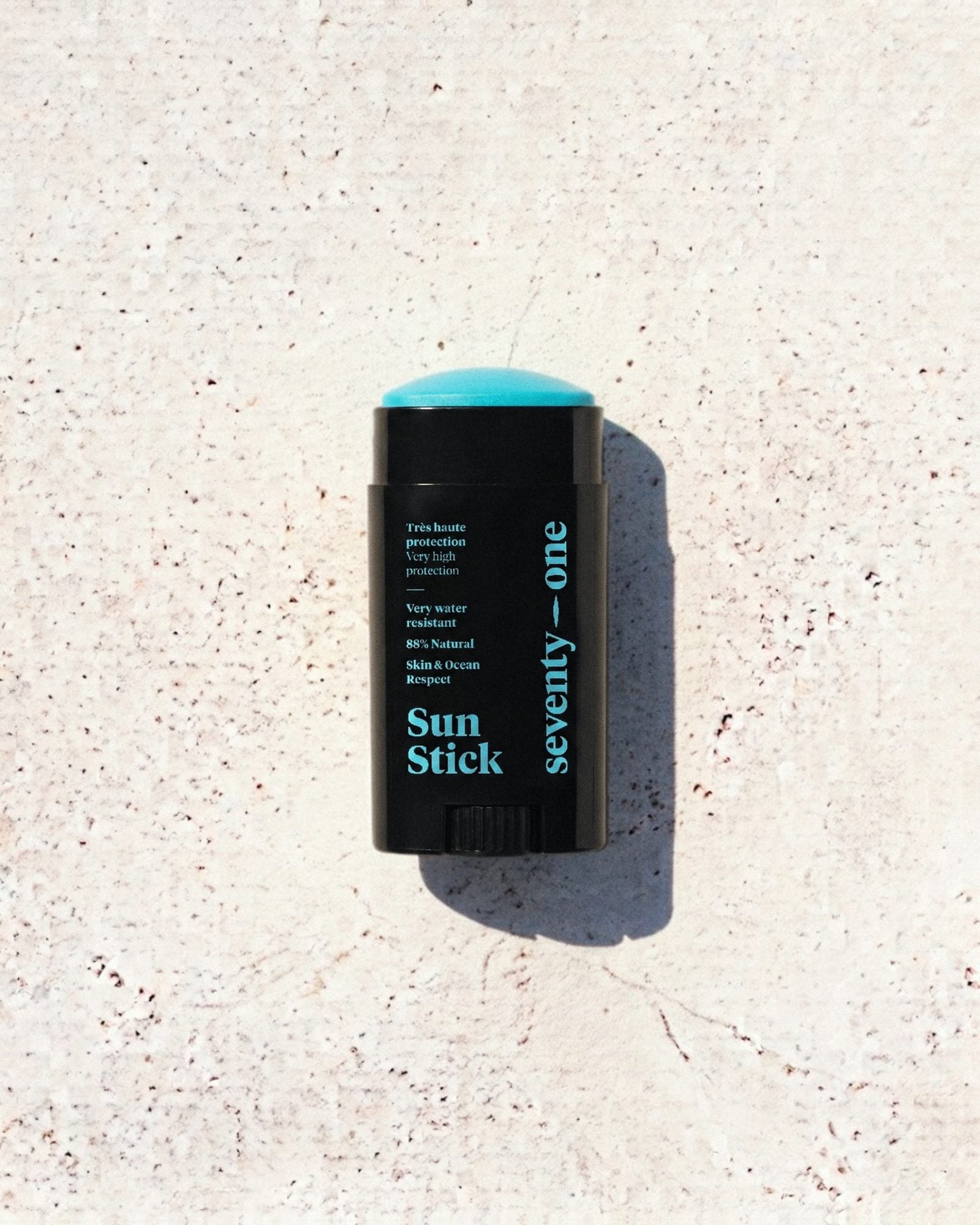 Stick solaire The Ocean Blue SPF 50+ SeventyOne Percent, très haute protection résistant à l'eau 15 g, posé sur une pierre blanche au soleil