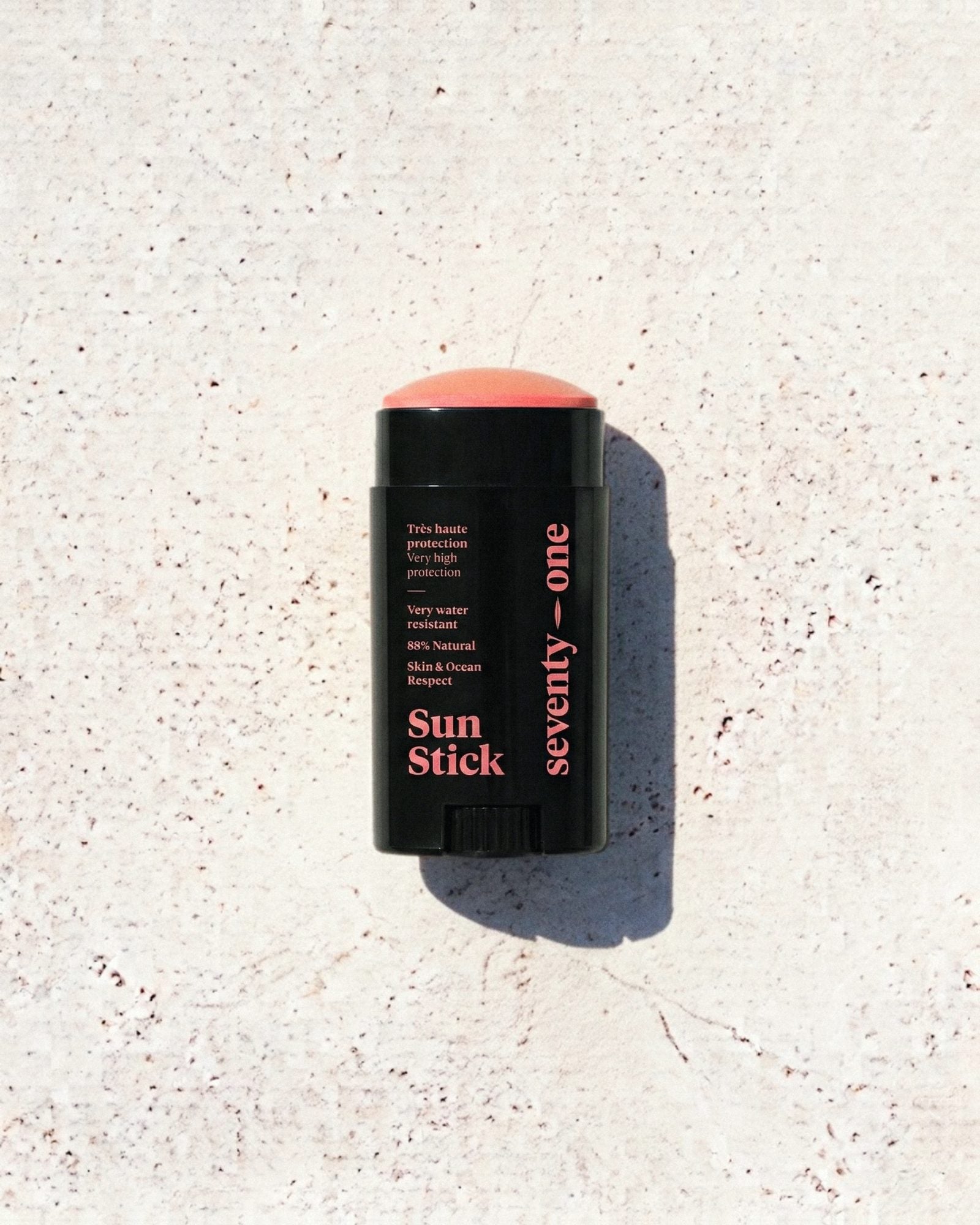 Stick solaire The Sunset SPF 50+ SeventyOne Percent, très haute protection résistant à l'eau 15 g, posé sur une pierre blanche au soleil